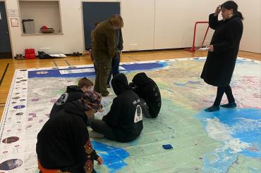 Students learning on an Indigenous map of Canada