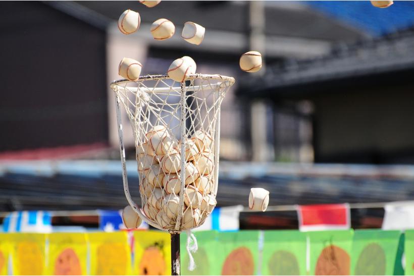 baseballs being thrown into a net